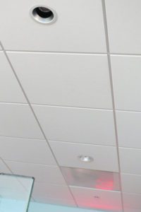 Typical suspended ceiling with lay in cileing tiles and light fixtures.